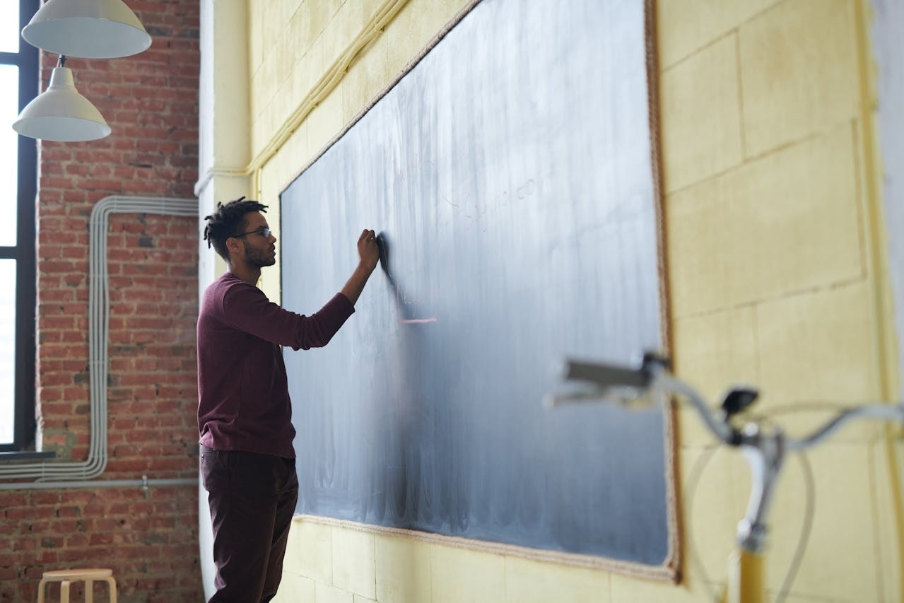 A man writing on a blackboard
