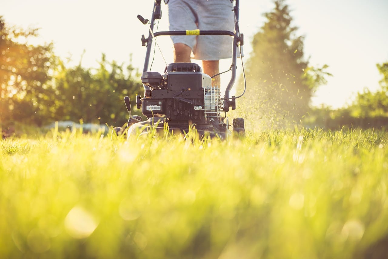 A person cutting grass with a lawnmower
