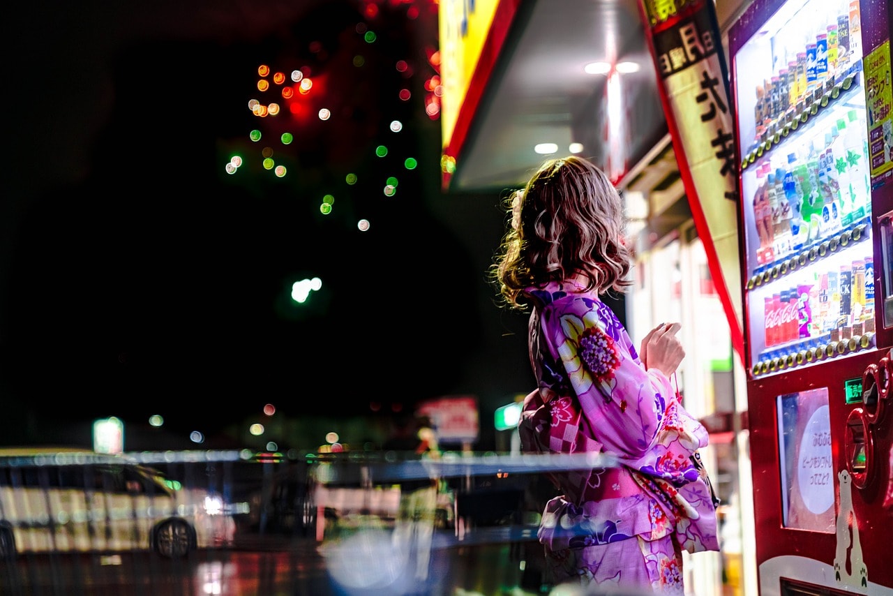 A woman getting a drink from a vending machine 