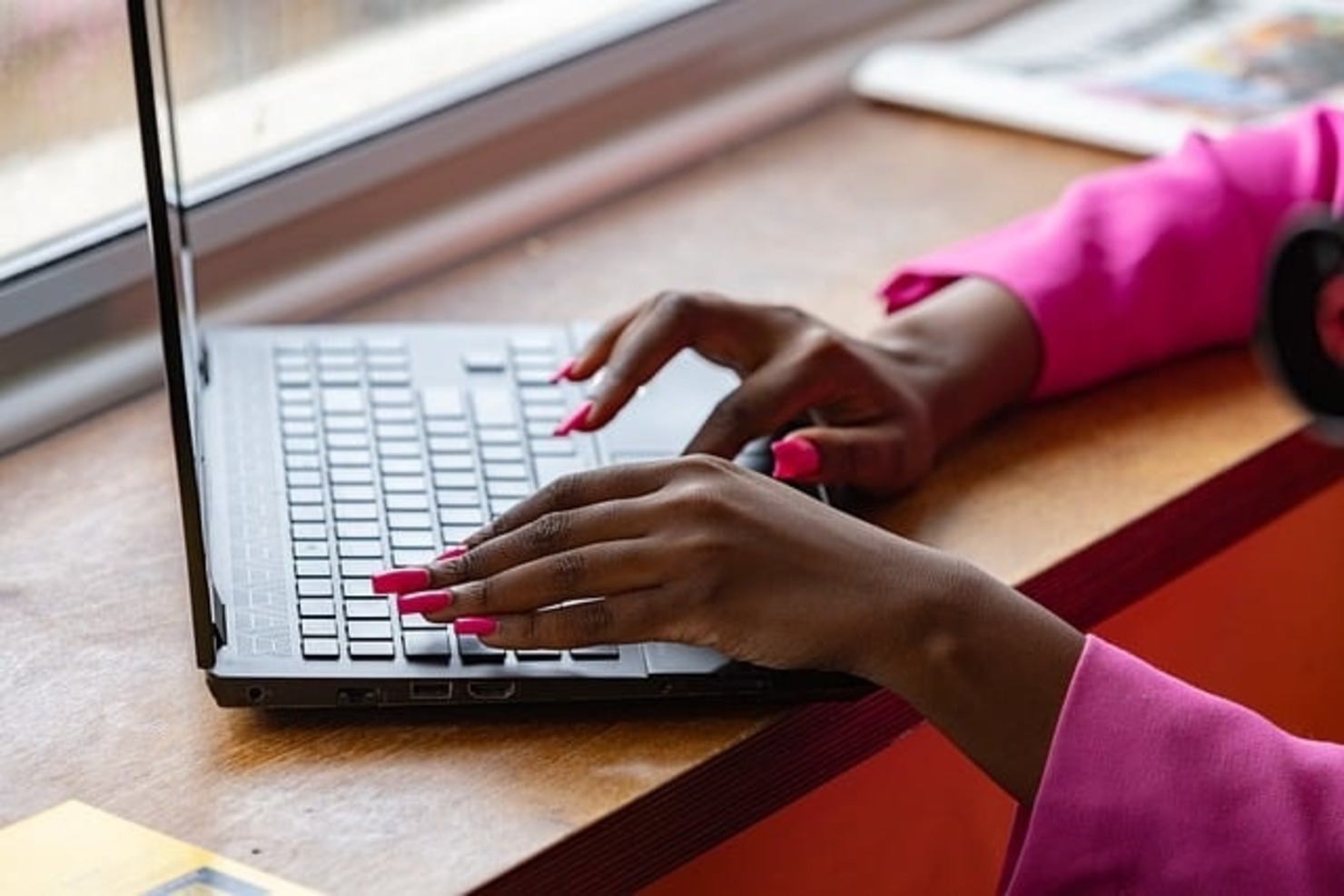 A woman is typing on a laptop