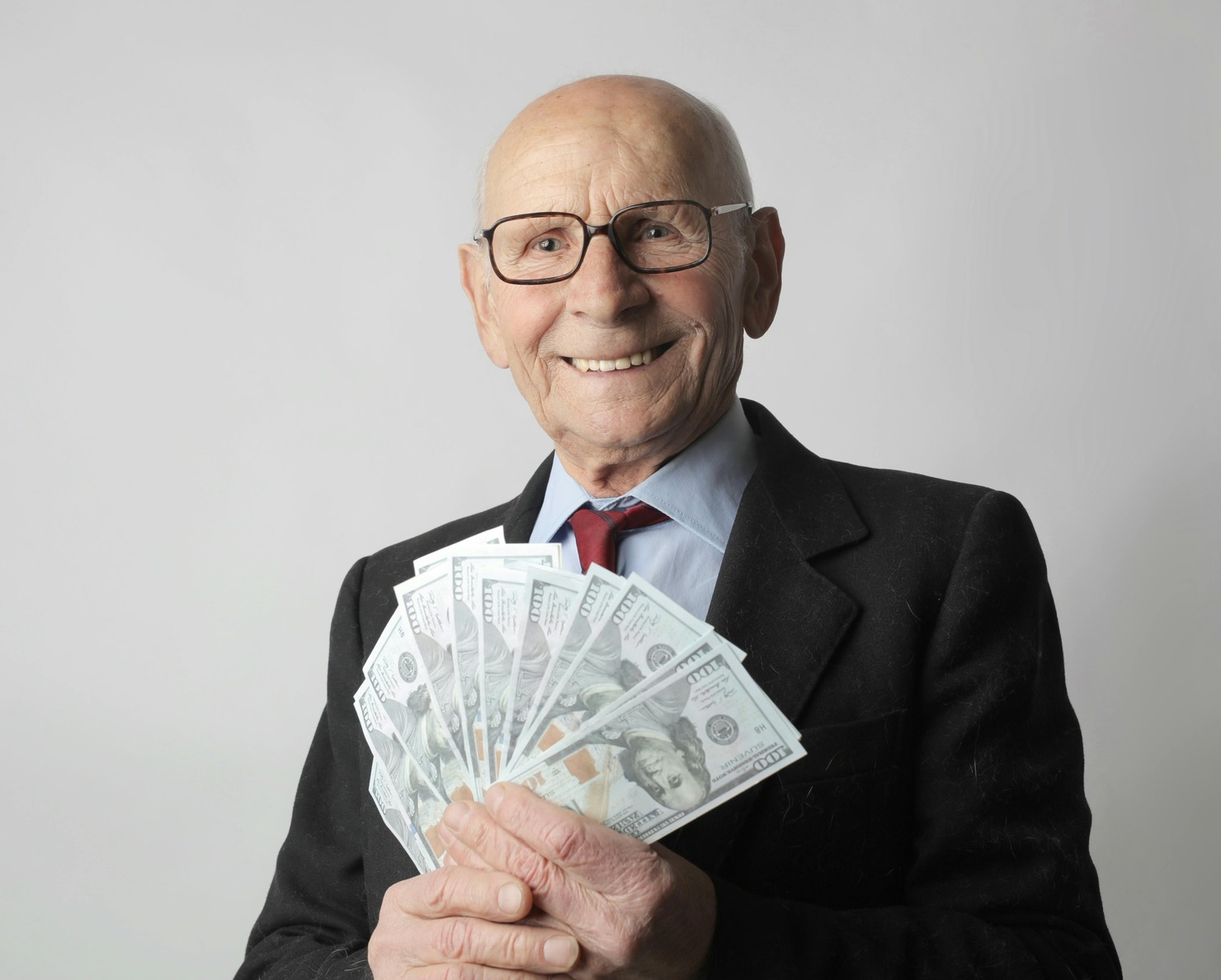 Man In Black Suit Holding Dollar Bills.