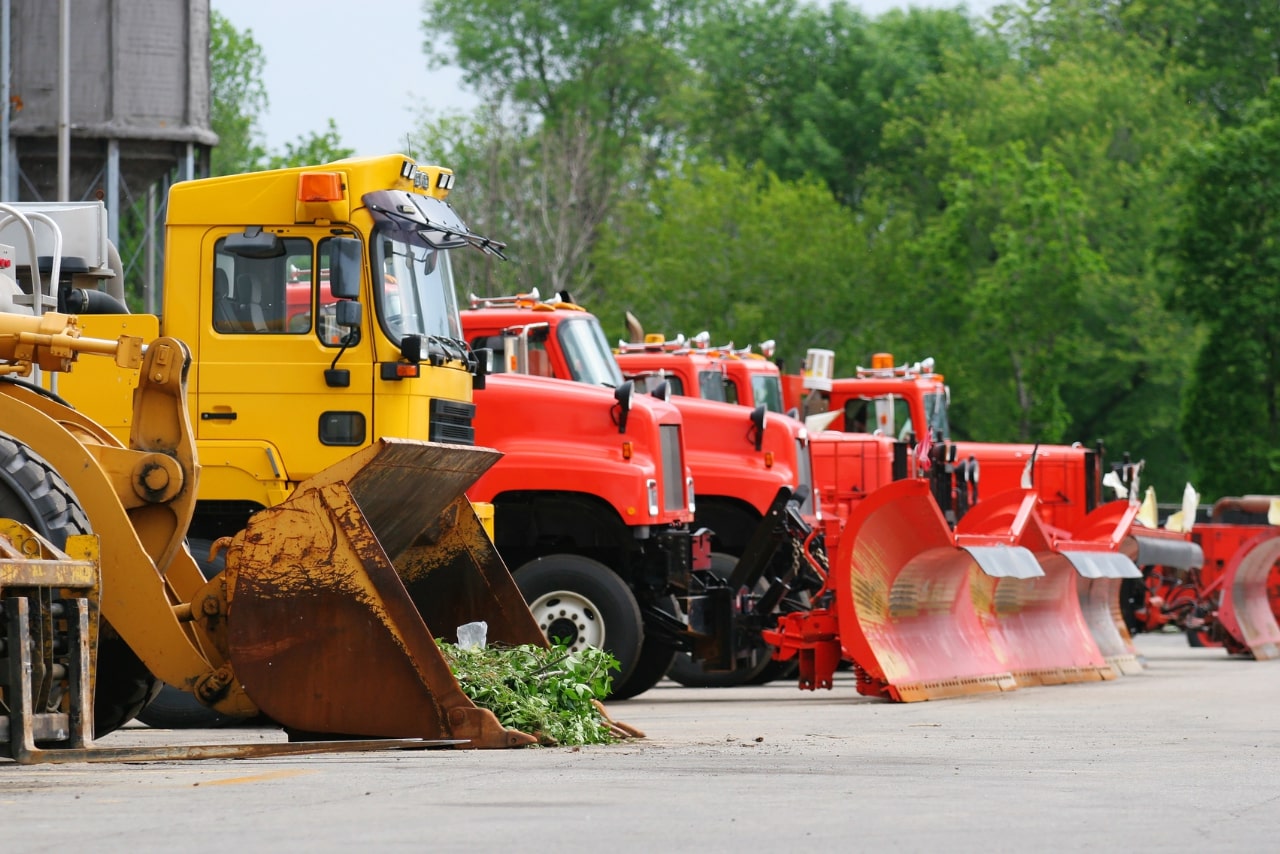 A Number of Road Equipment Vehicles parked on the side.