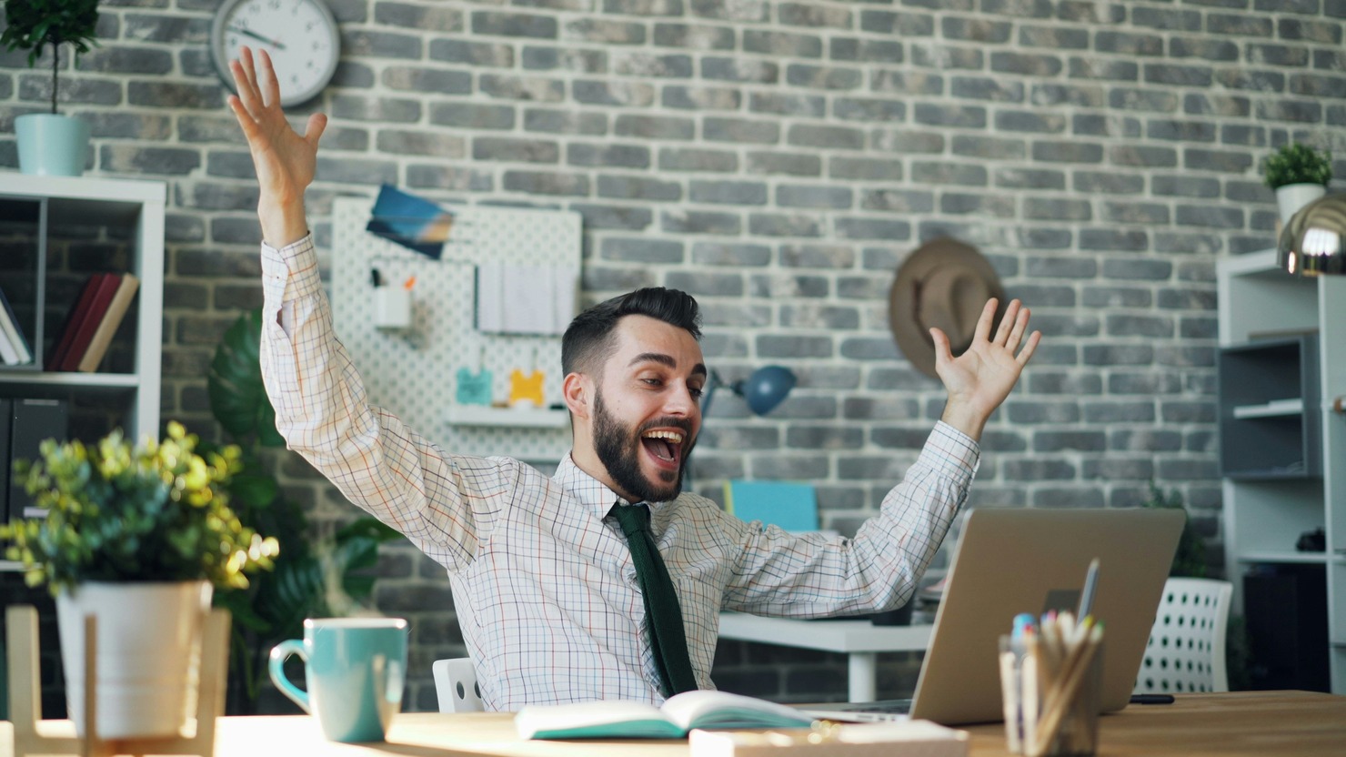 A happy man working on a laptop.