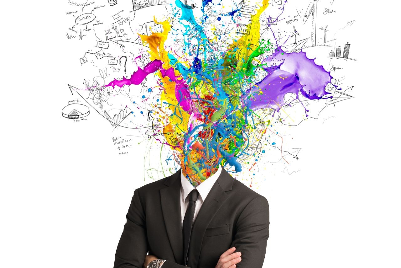 A headless figure surrounded by a burst of vibrant colors and abstract drawings, symbolizing a flow of creative ideas.
