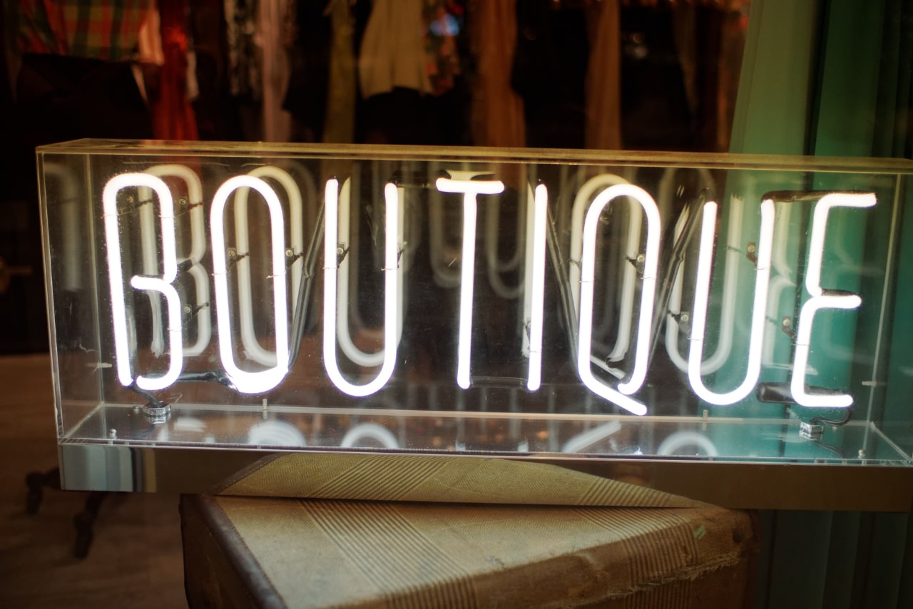 A neon sign with the word BOUTIQUE lit up in bright white lettering.