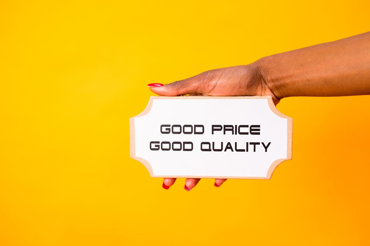 A person holding a sign that reads Good Price Good Quality
