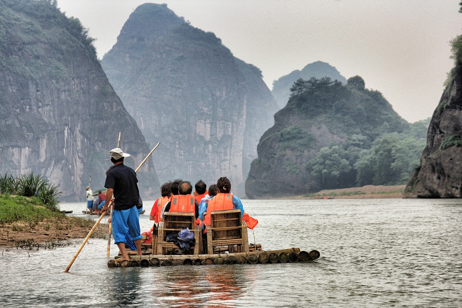A tour guide helping cross the river.
