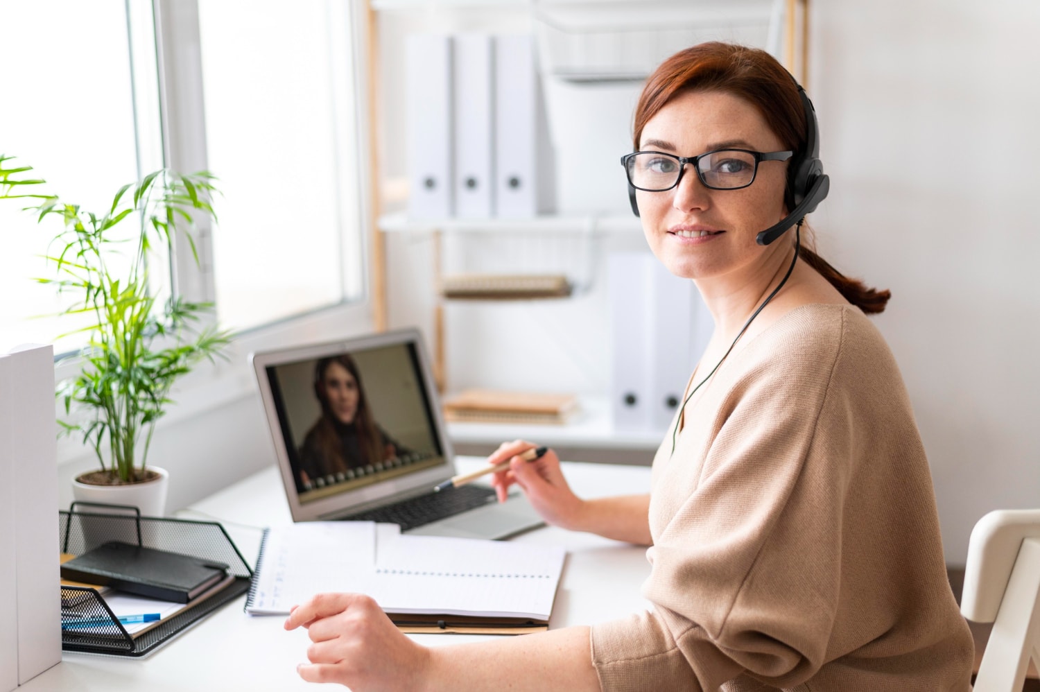A woman at work having video call on laptop.