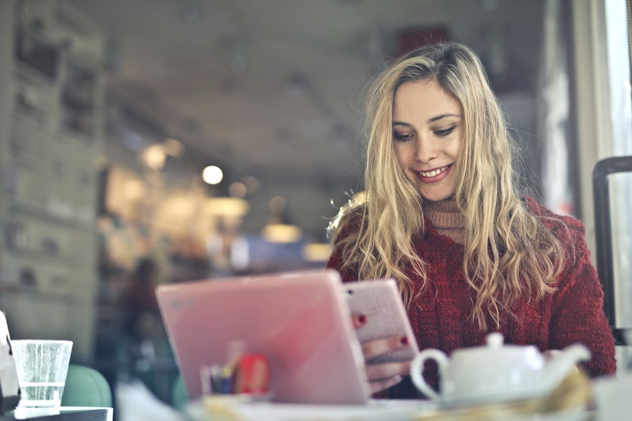 A woman in red sweater holding a mobile phone
