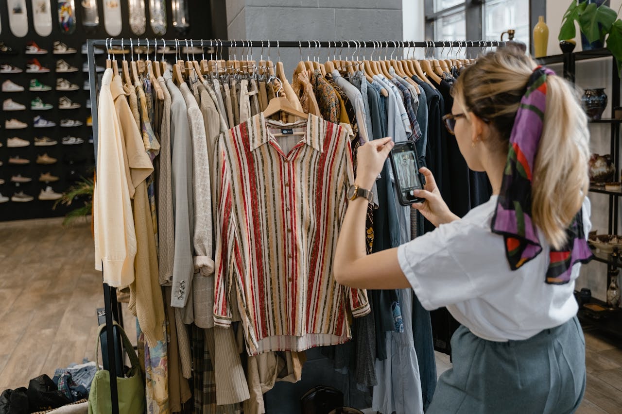 A woman taking a picture of a vintage blouse