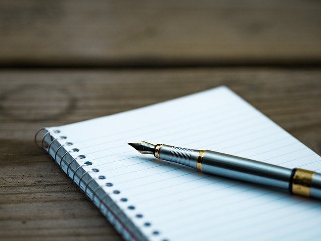 An image of a fountain pen and notebook.