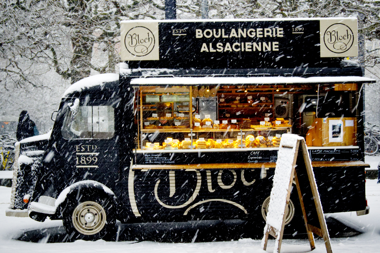 Black boulangerie alsacience Food Truck open while snowing outside.