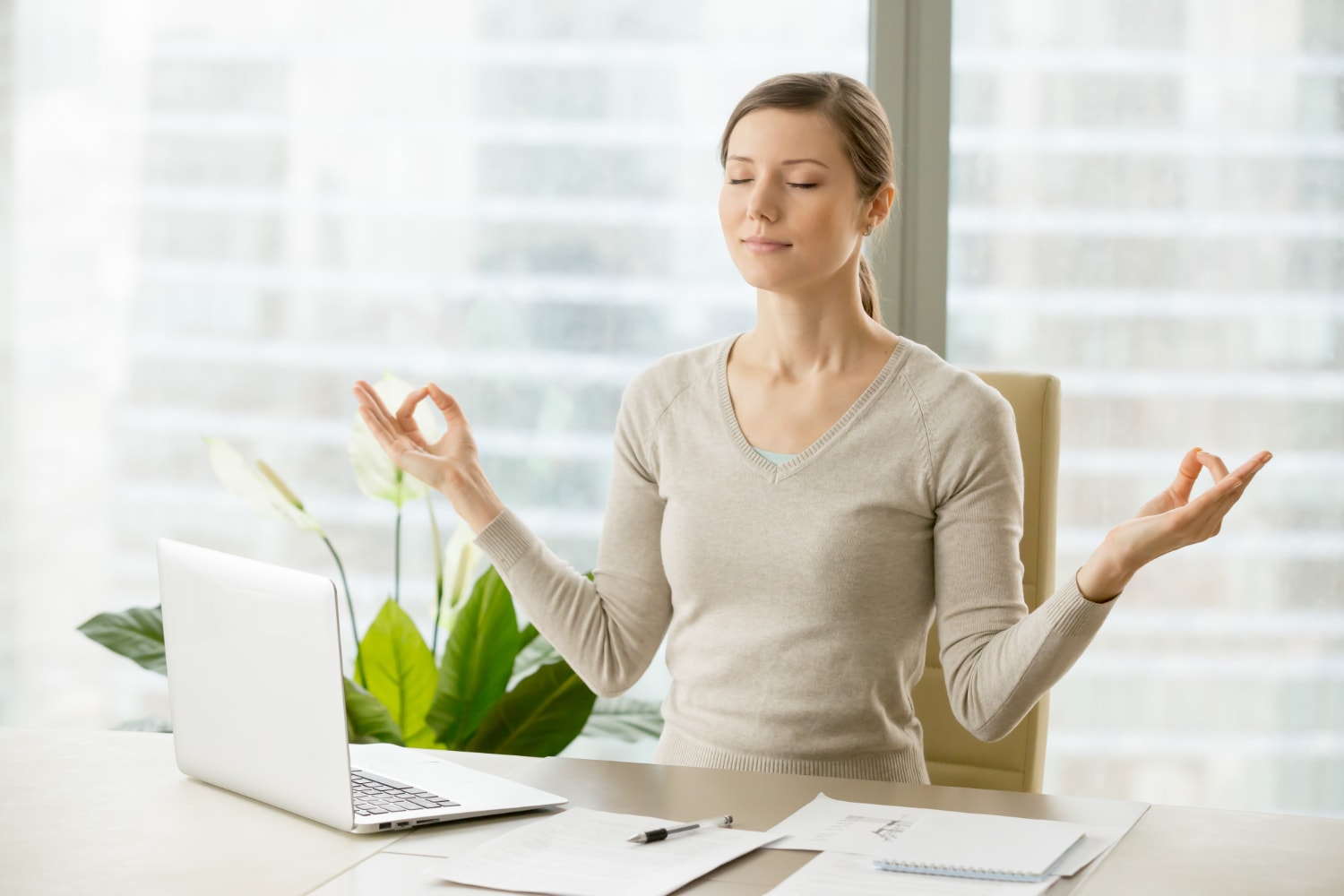 Calm businesswoman relaxing with breath exercises.