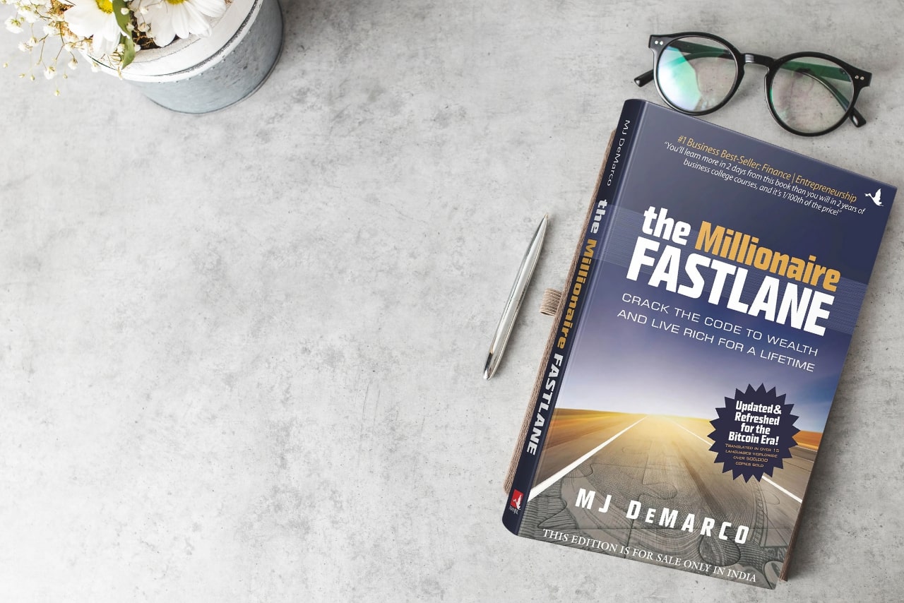 https://cdn.hostadvice.com/2025/01/Eyeglasses-and-the-The-Millionaire-Fastlane-book-on-desk.jpg
