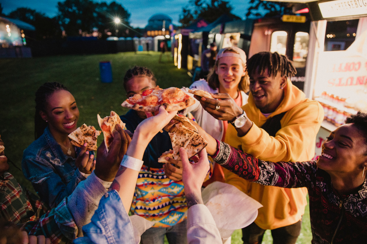 Festival goers sharing pizza.