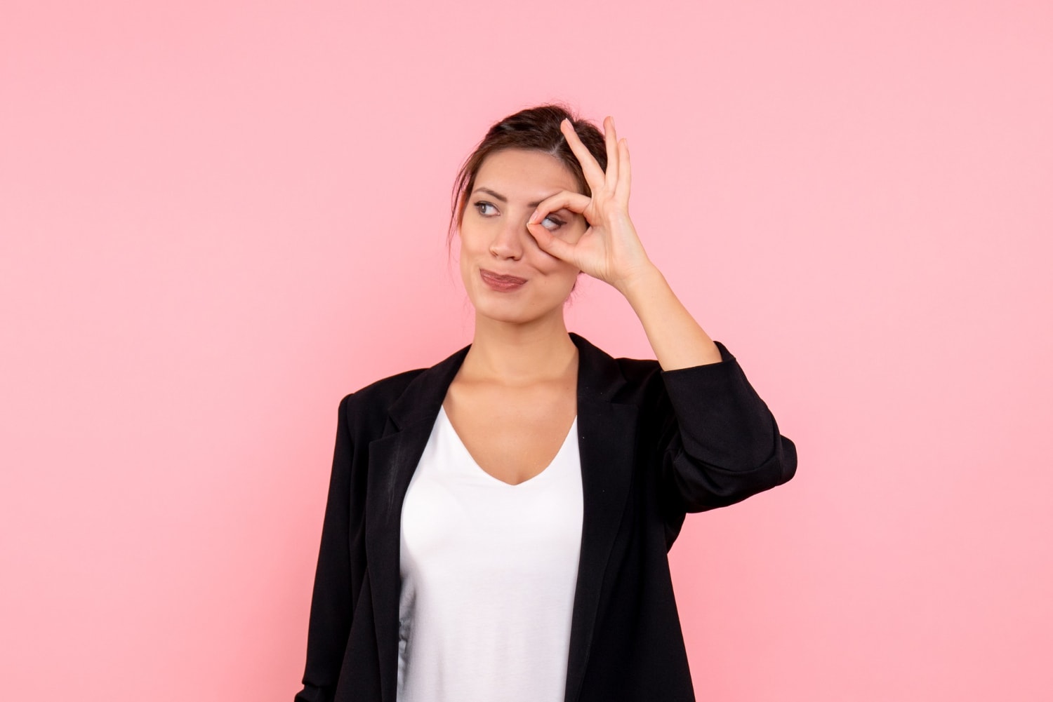 Front view young female in dark jacket on pink background.
