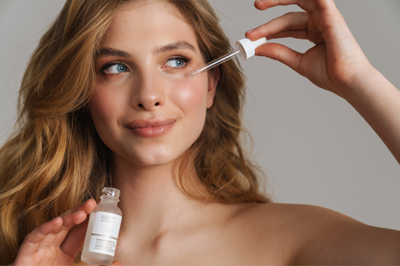 Ginger hair woman applying serum on face.
