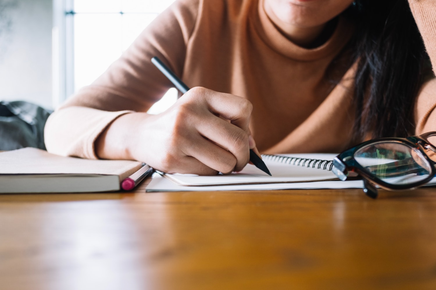 Girl writing in notebook.
