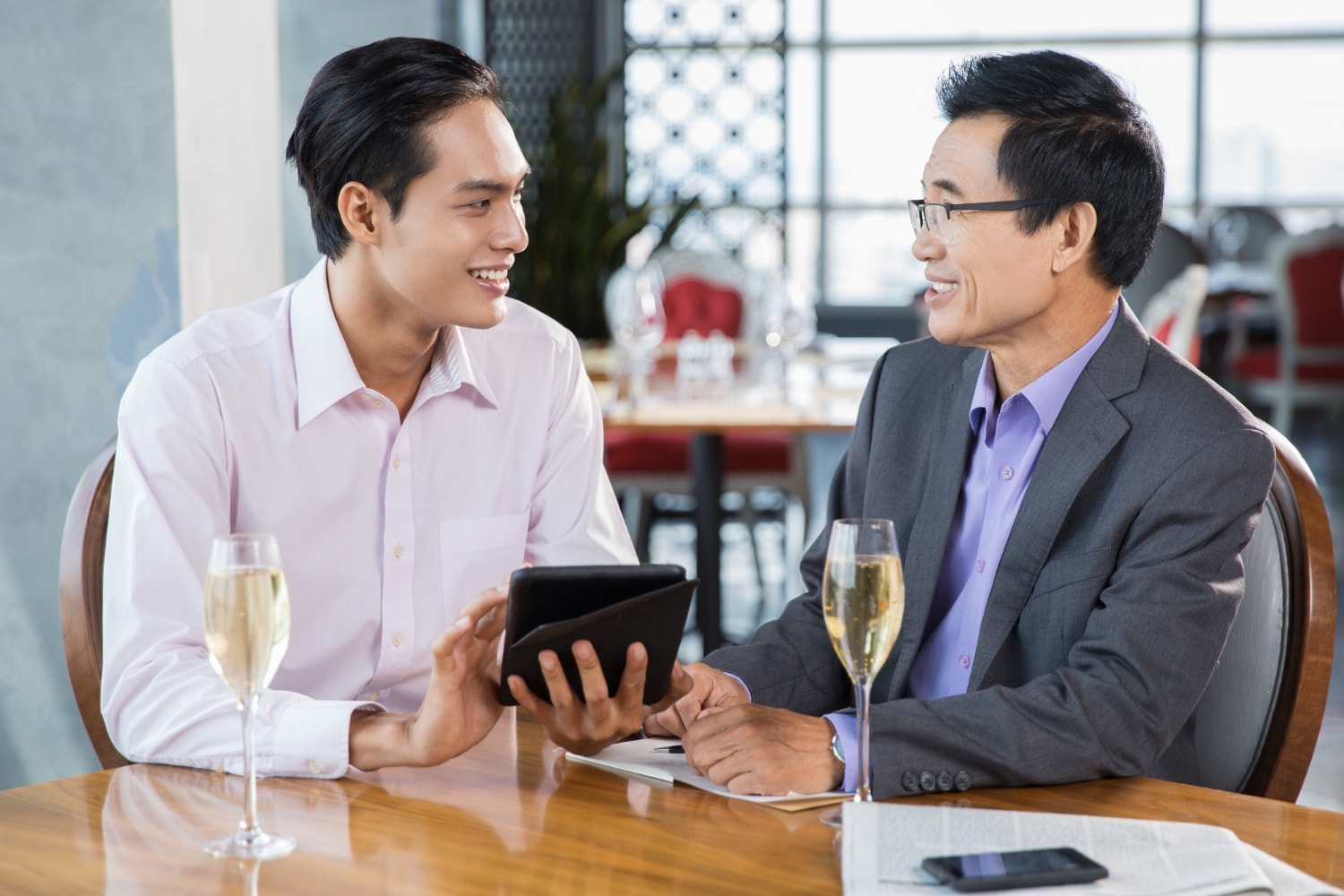 Happy Businessmen Discussing Project in Restaurant.