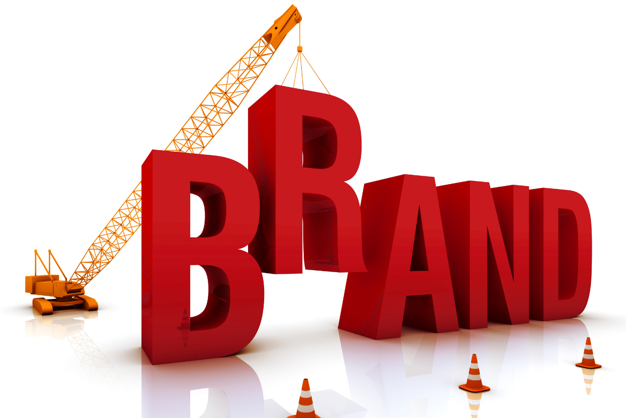 Large and bold red letters spelling the word BRAND, with a crane actively lifting the letter R into place. 