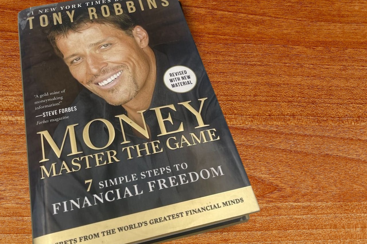 Money, master the game book laying flat on table.
