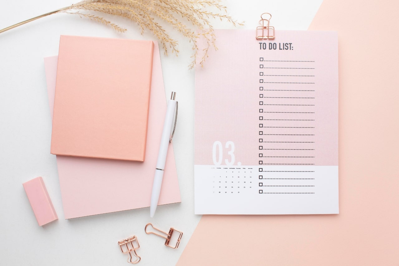 Printed planner, pen and notebooks on display.