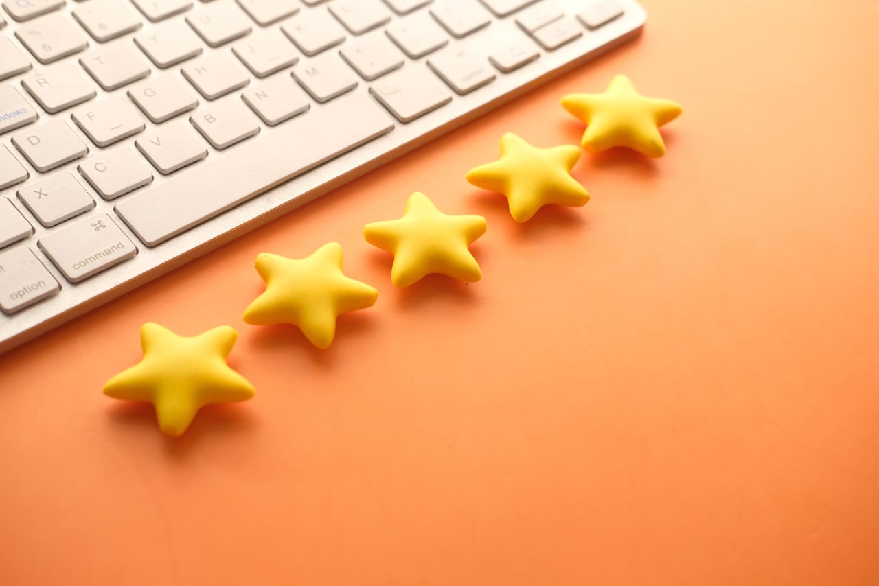 Rating golden stars on orange background and keyboard.