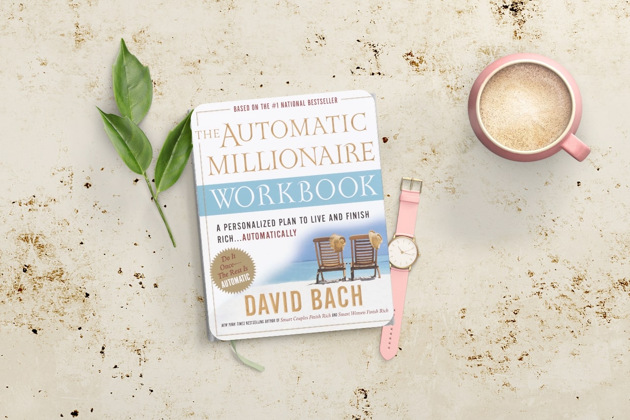 The Automatic Millionaire book on counter top with watch and coffee.