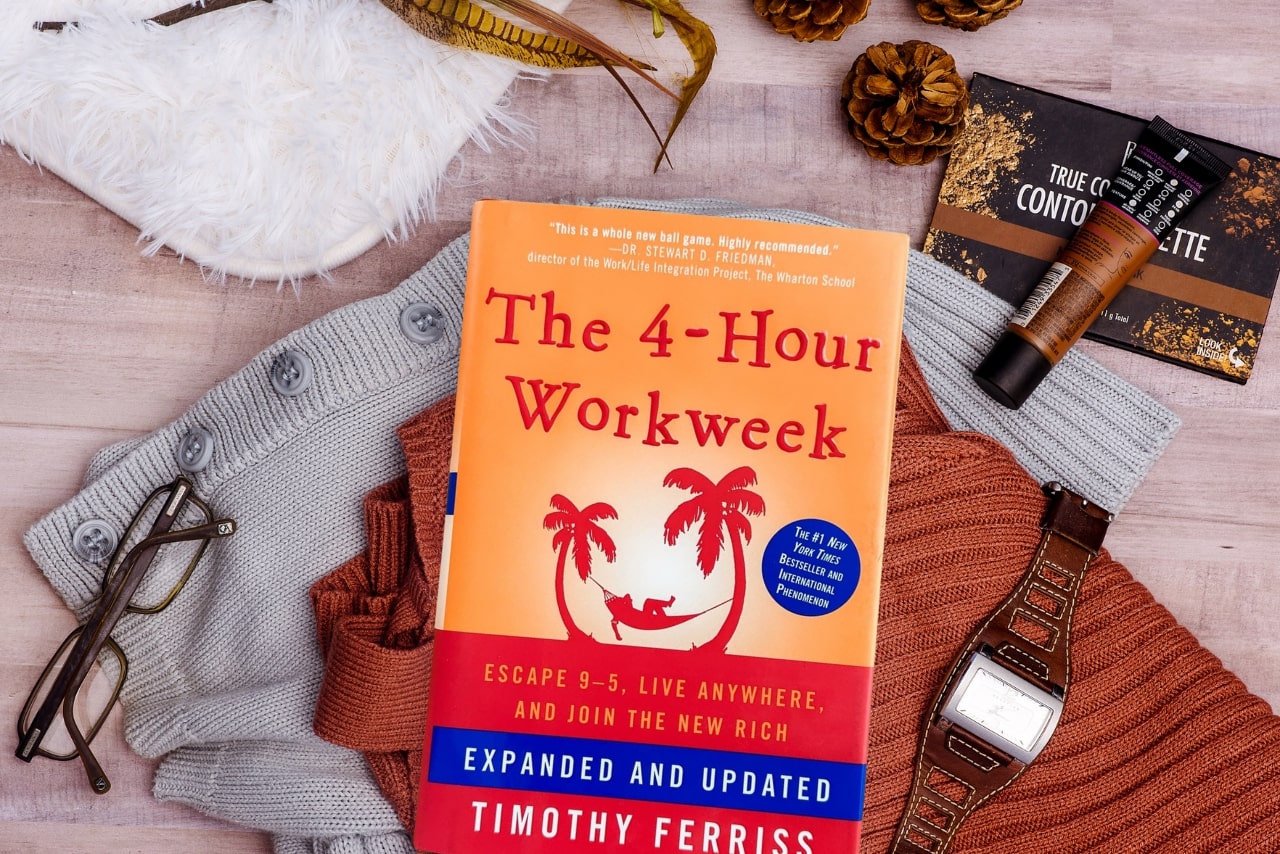 The The 4-Hour Work Week book on top of clothes.