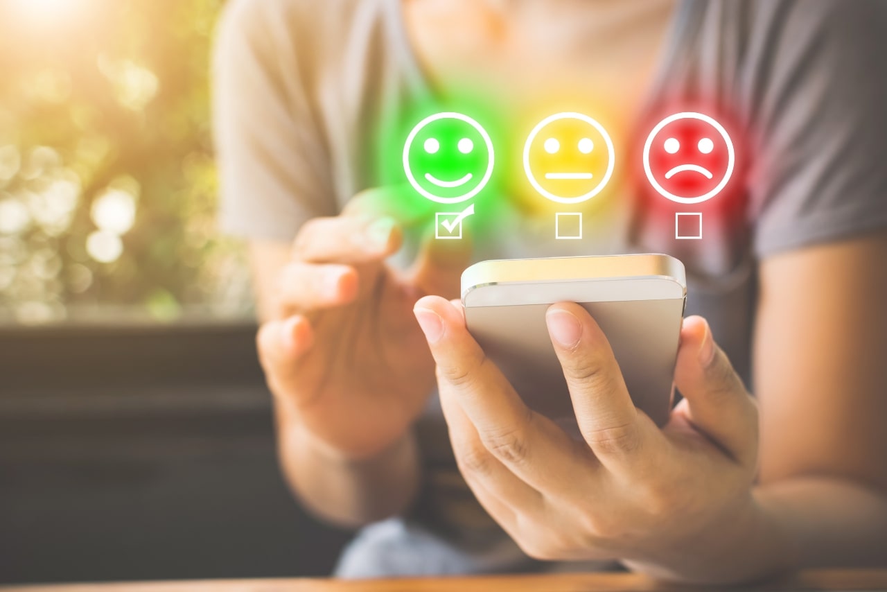 Woman choose smile icon on smart phone.