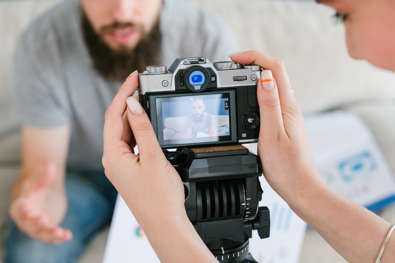 Woman holding camera to create video content for online course.