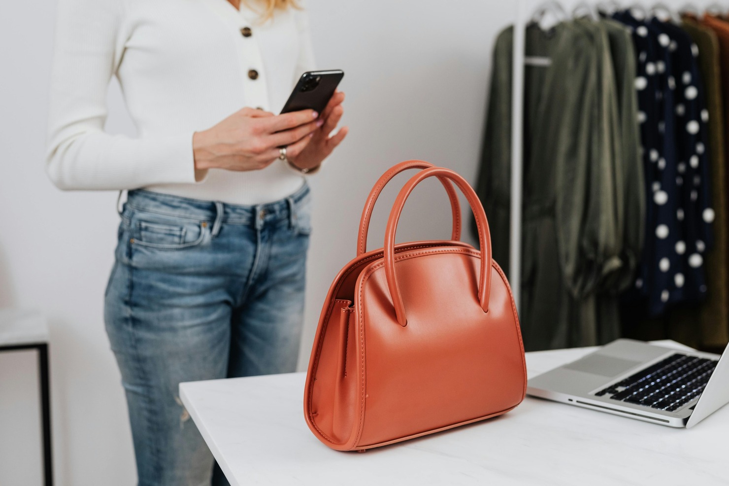 Woman photographing a bag for online sale.