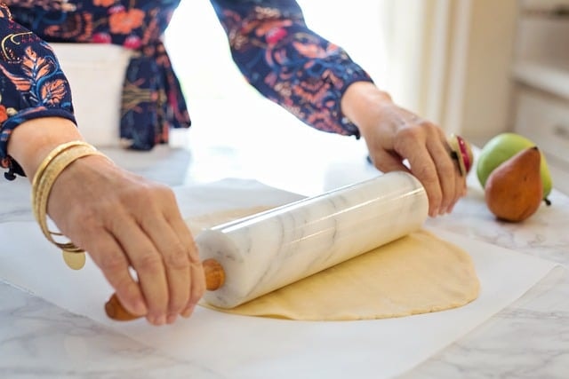 Woman using rolling pin to make pie.