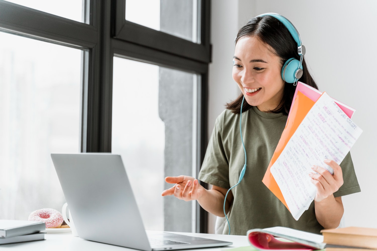 Woman with headphones having video call on laptop.