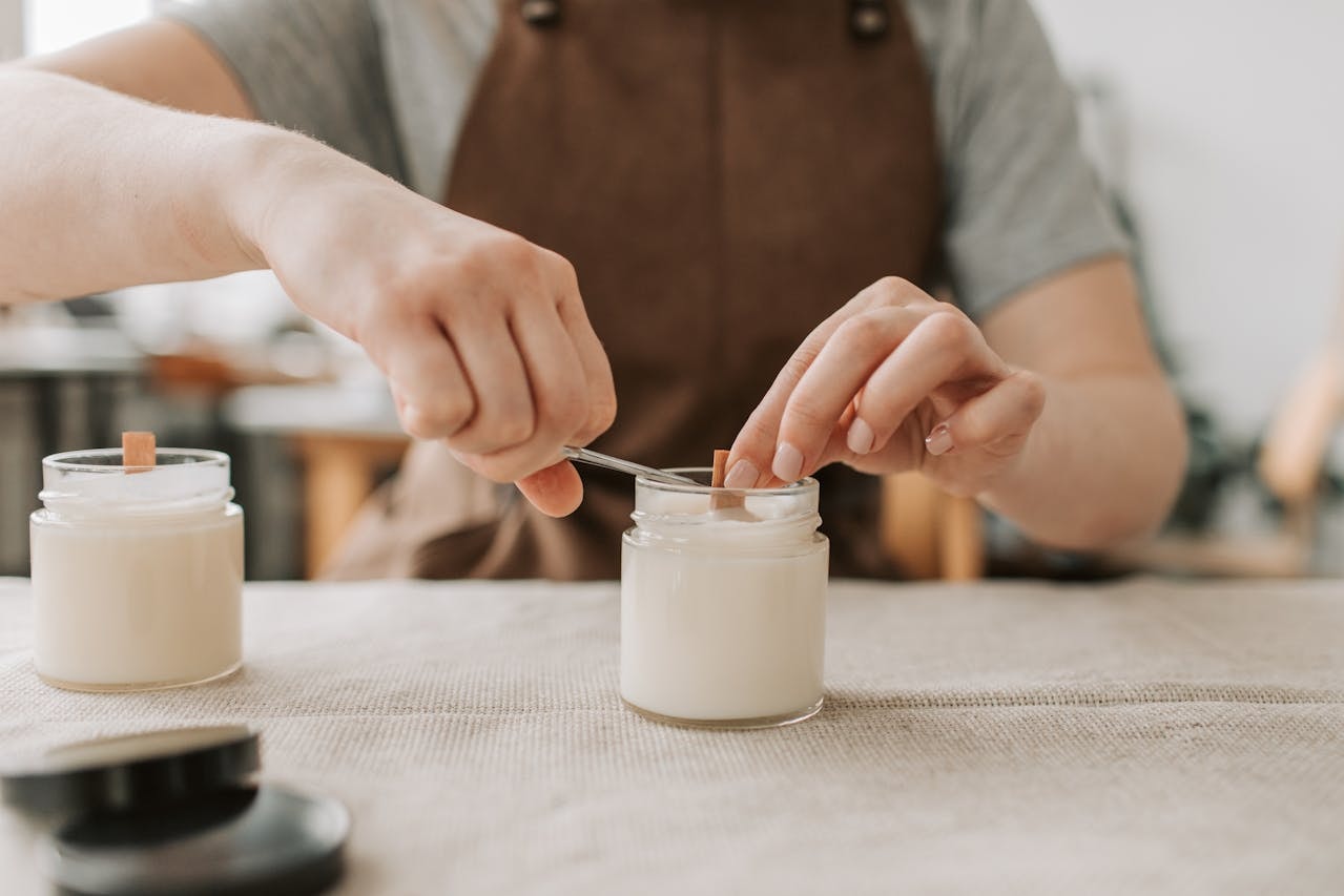A close-up shot of a person cutting the wick of a candle