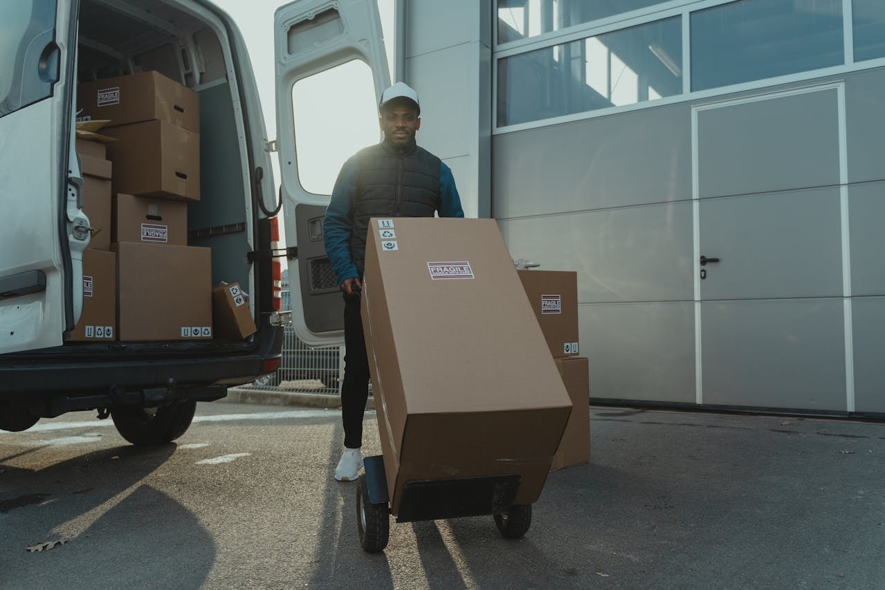 A delivery man moving a large box with a fragile sticker