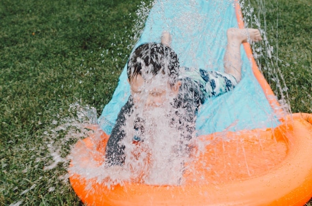 A kid playing on a water mat
