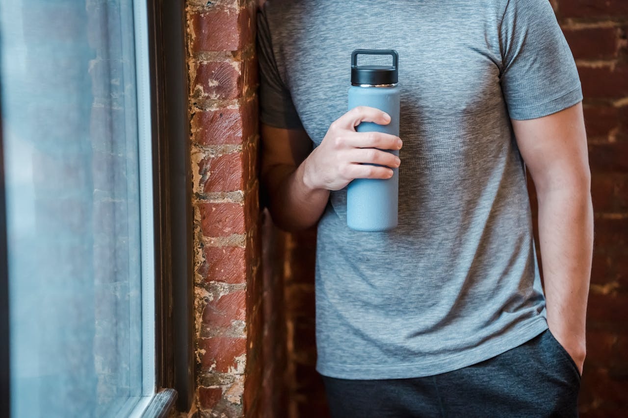 A man holding a blue water bottle
