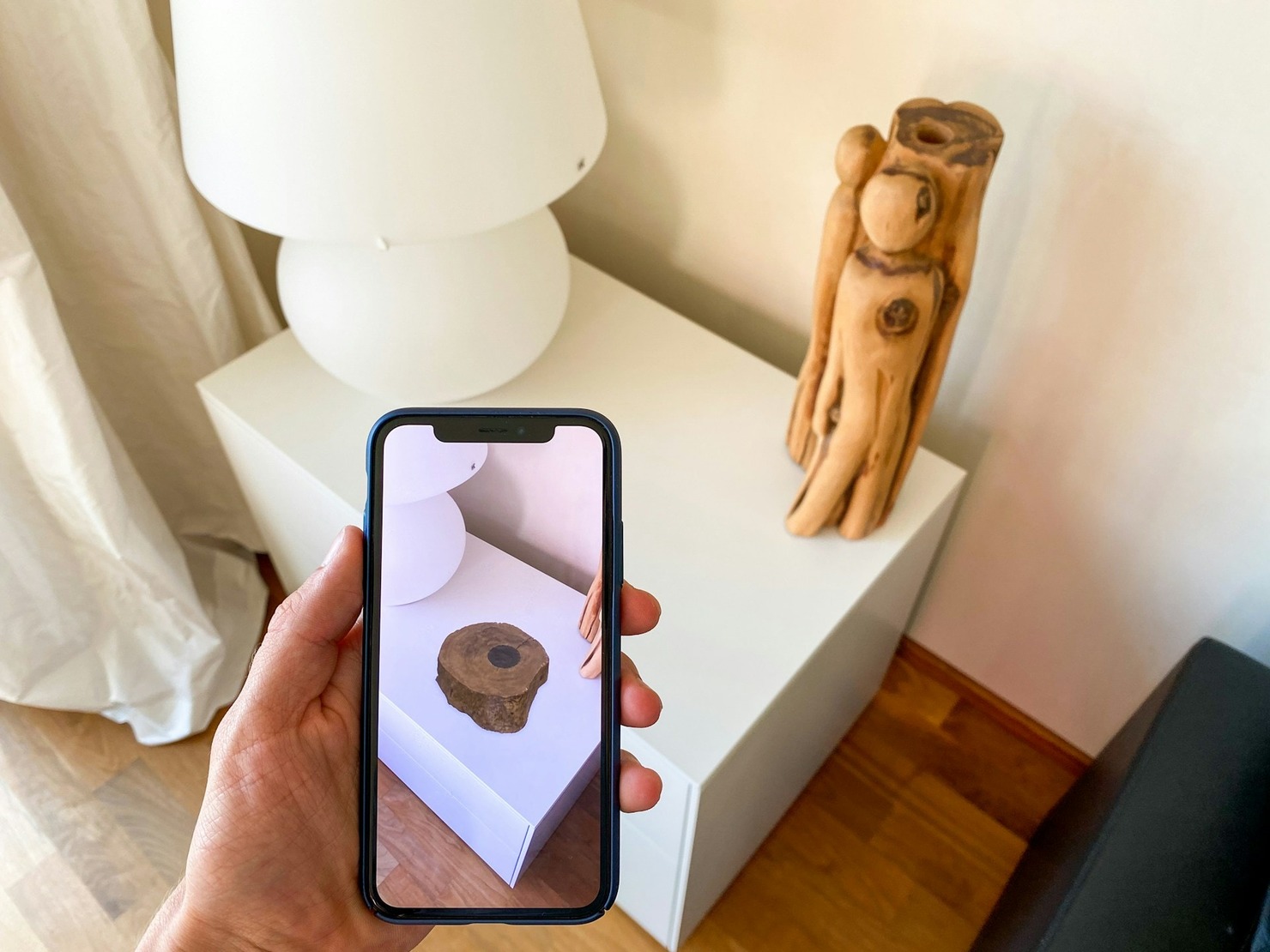 A person taking an augmented-reality photo of a furniture