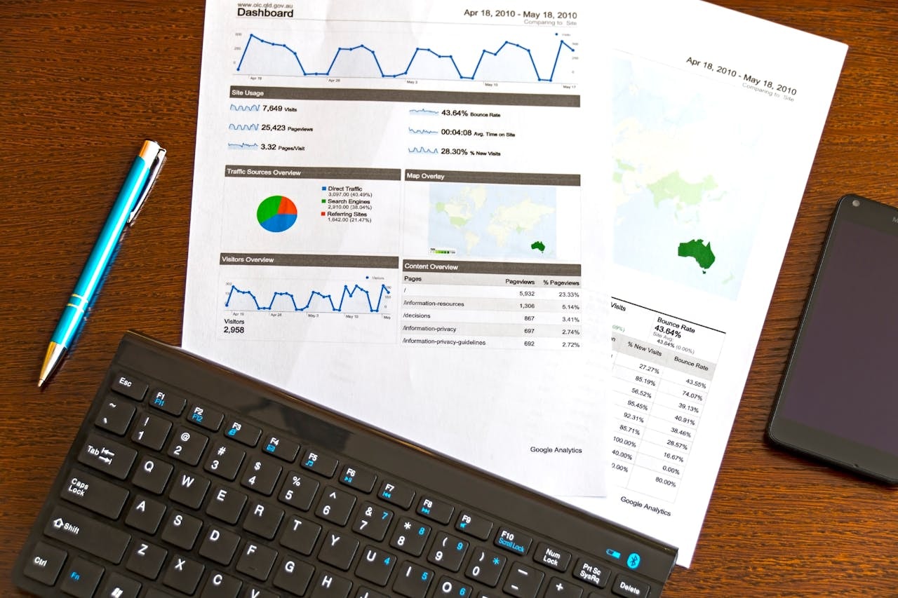 A photo of a document with charts next to a keyboard and a pen