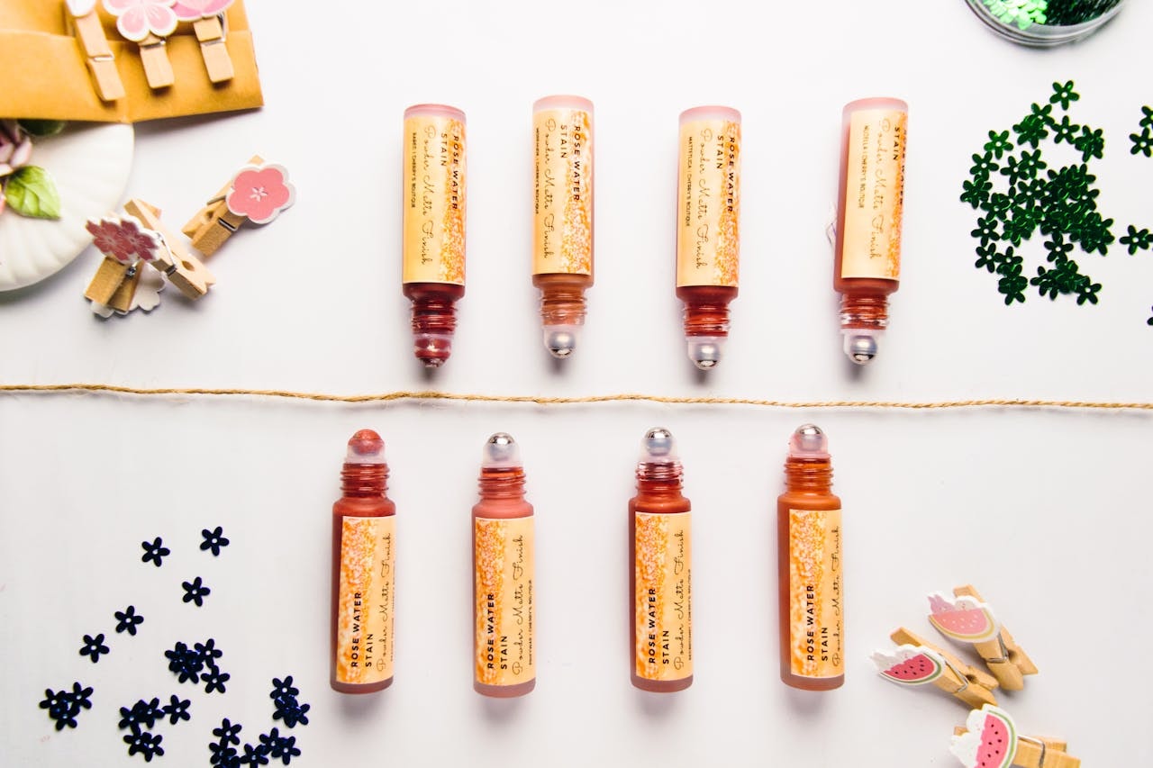 A photo of lip tint in various shades surrounded by tiny flower props