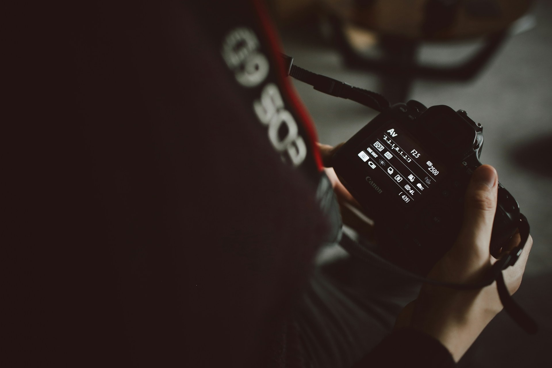 A photographer changing the settings of a DSLR camera
