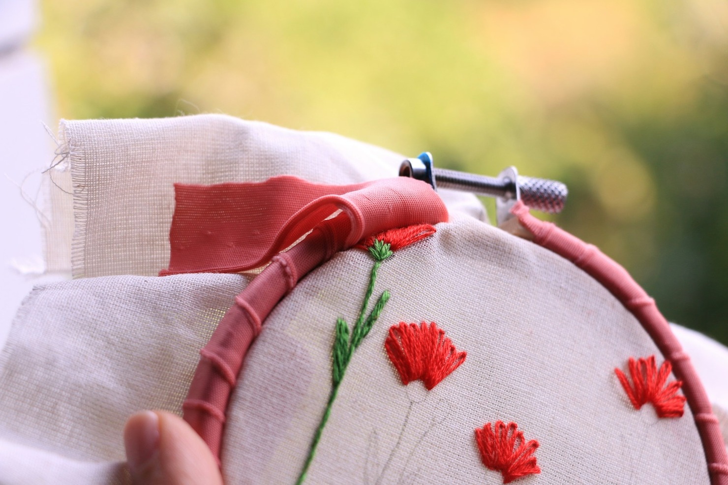 A piece of cloth embroidered with red flowers