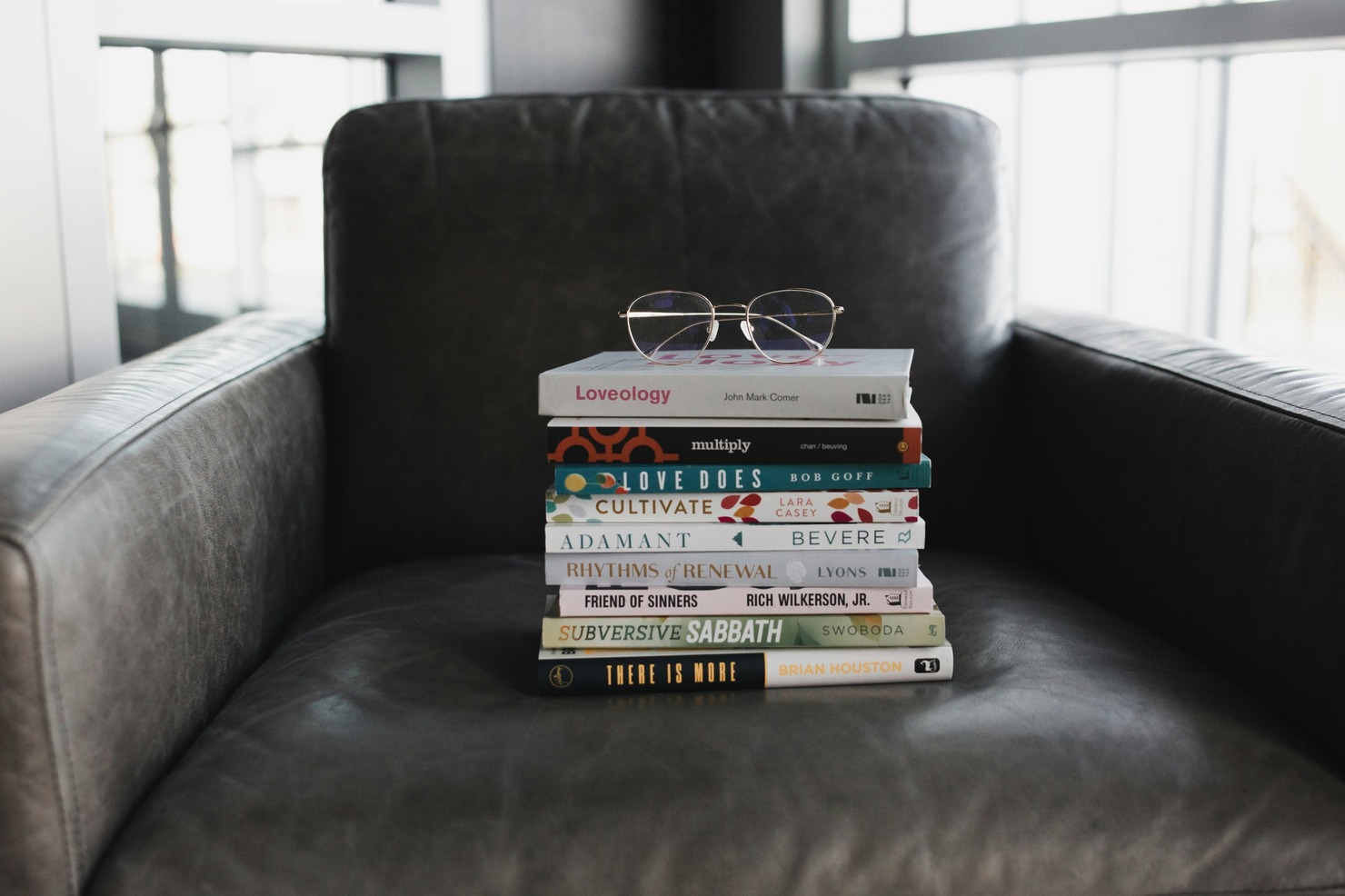 A stack of books on a couch.