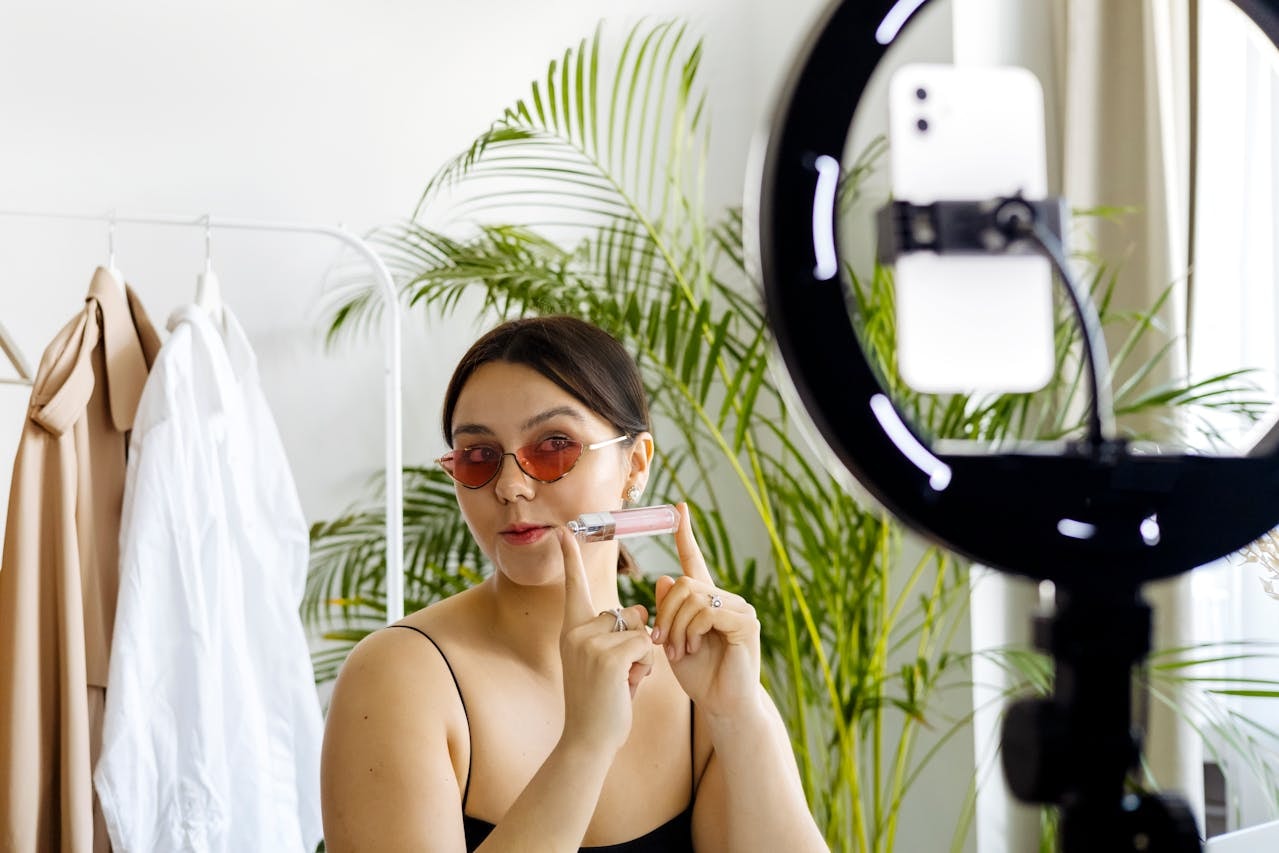 A woman holding a cosmetic product in front of a camera