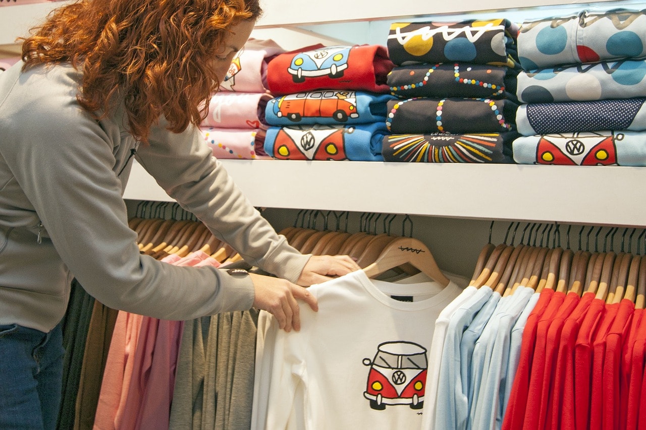 A woman selecting t-shirts.