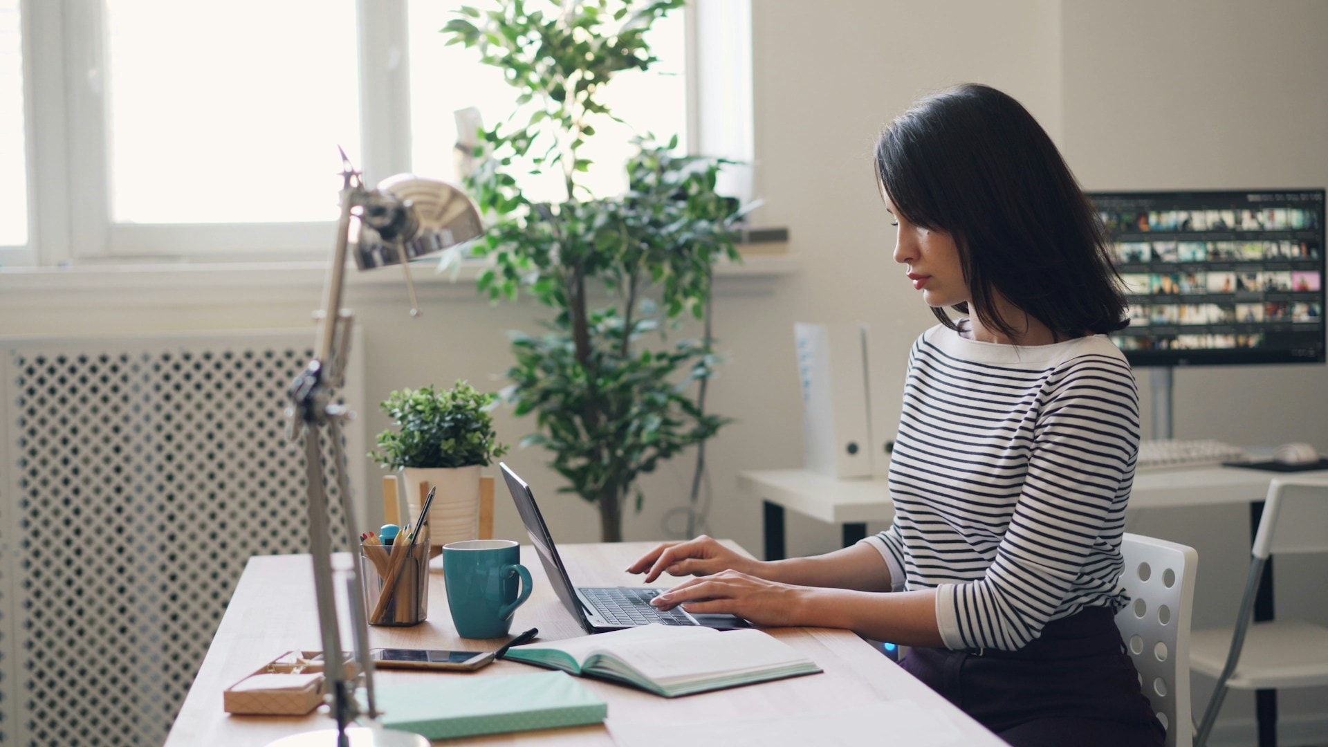 A woman sitting at her desk and working on her laptop