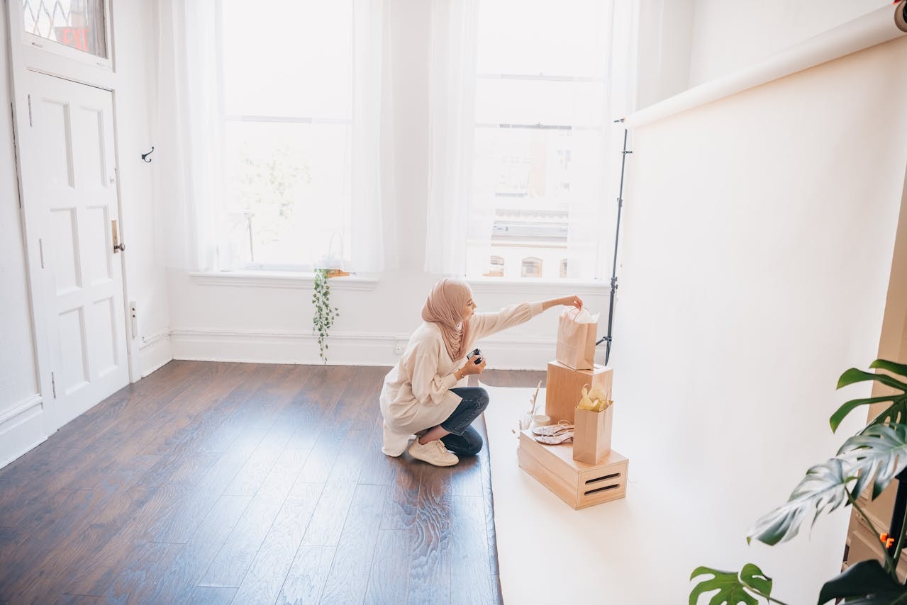 A woman taking product photos using a white backdrop as background