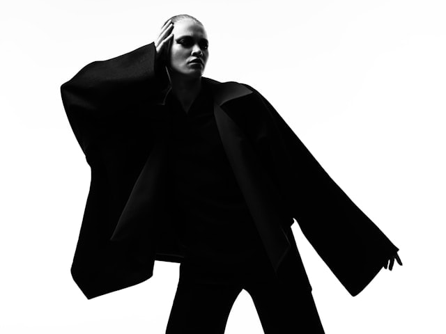 A woman wearing a black oversized coat