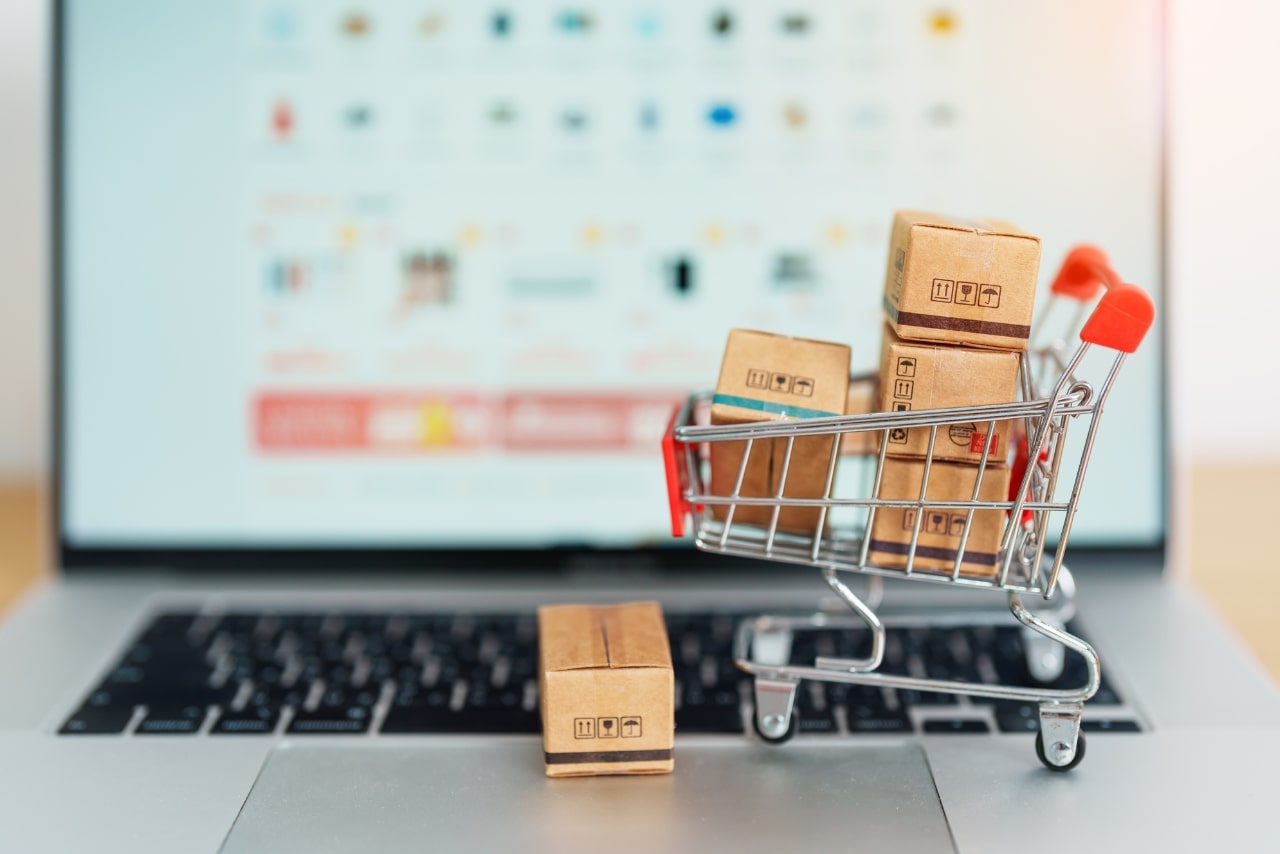Boxes with shopping cart on a laptop computer signifying online business.